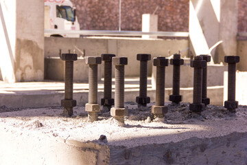 Close up view of the anchor bolts (Foundation Bolts) in the concrete. Anchor bolts are used to connect structural and non-structural elements to the concrete. The connection is made by an assembling.