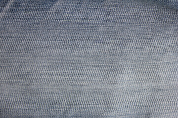 Denim jeans pale blue fabric texture. Casual trousers style, cloth piece of classic blue jeans with blank copy space. Fashion design backdrop, simple jean cloth