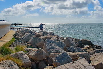 The fishing lesson, a father teaches his son sea fishing