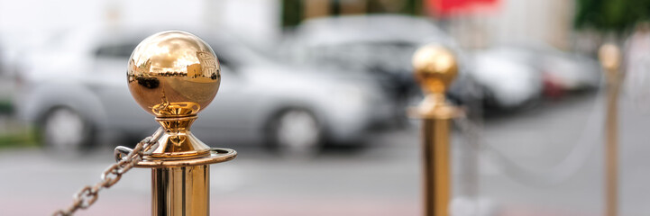 golden glass decorative columns balustrade on sidewalk of city street hotel parking lot background
