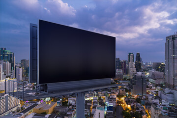 Blank black road billboard with Bangkok cityscape background at night time. Street advertising poster, mock up, 3D rendering. Side view. The concept of marketing communication to promote idea.