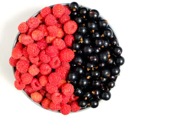 Raspberry and blackcurrant berries in a Cup view from the top on a white background.