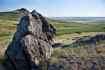Lonely large stone on a hill above the fields.