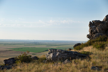 Beautiful view of cliff stones over green fields.