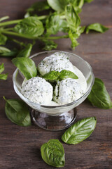 Homemade basil ice cream with fresh basil on a dark background. Copy space