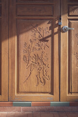 Sunlight and shadow on the old vintage wooden folding door surface on brick floor in vertical frame