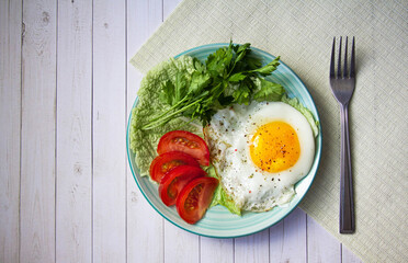 fried egg with tomatoes and parsley on wooden background