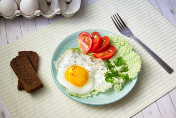 fried egg with tomatoes and parsley on wooden background