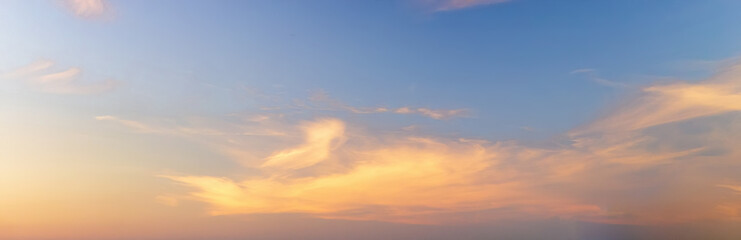 Light soft panorama sunset sky background with clouds illuminated by sun