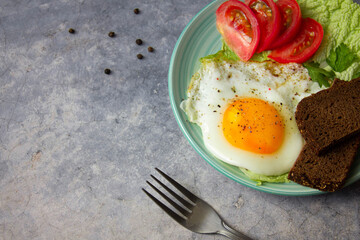 fried egg with tomatoes on marble rock background