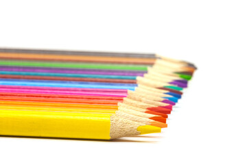 colored pencil set loosely arranged on white background, selective focus