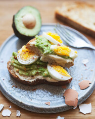 Avocado Toast with Hard Boiled Eggs, Hummus, Red Pepper Flakes, and Black Pepper.