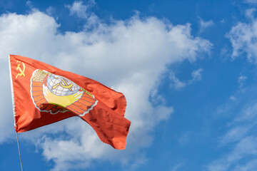 red USSR flag with soviet emblem on sky background