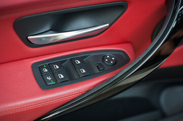 Plakat Control panel for electric windows on driver's door, detail of interior of modern car with red leather on background