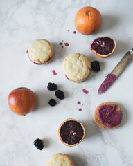 Flatlay of blood orange blackberry cookie sandwiches on marble surface