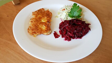 Pork chop and salad of finely chopped cucumbers and beets on a plate