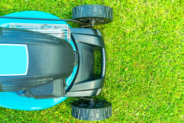 Mowing lawns. Top view lawn mower on green grass. Mower grass equipment. Mowing gardener care work...