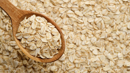 oatmeal in wooden spoon and on background. flakes, сereals