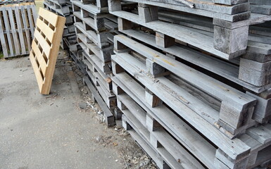 stacked wooden pallets. Wooden production pallets stand piled in a pile. Close-up.