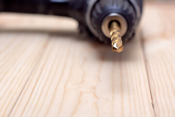 Drill on wooden table, drill bit closeup, work tool