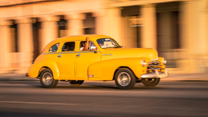 Obraz na płótnie Canvas Auto clásico en el malecón de La Habana al atardecer