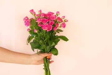 Girl's hands holding Beautiful bouquet of pink roses on light background