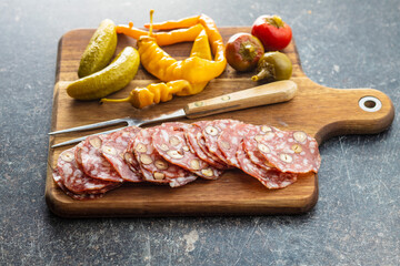 Sliced italian salami with hazelnuts, pickled chili peppers and pickles