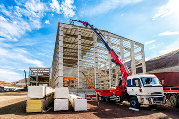 The crane (HIAB) extend its lift bucket to roof of the new building for isolation in the...