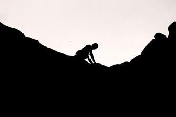 Black and white photo of person rock climbing 