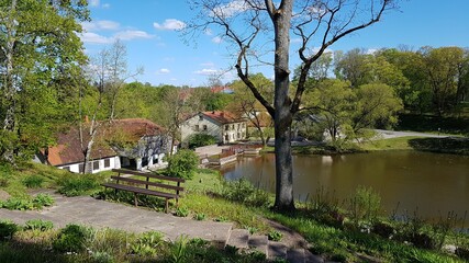 Obraz premium Houses on the shore of a reservoir in the Latvian village of Aizpute in May 2020