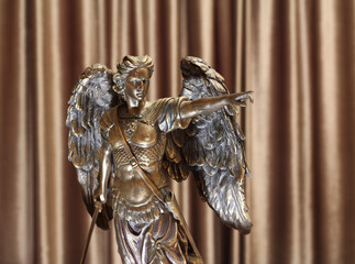 Statuette of the Archangel Michael on a velour background.