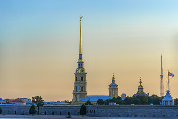 Fototapeta na wymiar Sunrise view of Petropavlovskaya (Peter and Paul) fortress and orthodox Peter and Paul Cathedral on Zayachy Island after summer white night. Saint-Petersburg, Russia