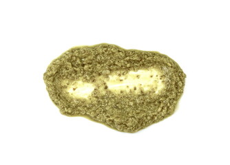 Pesto spread or blob in a bowl isolated on white background. Green italian homemade spilled sauce made of ground basil, garlic, pine seeds, olives and pecorino sardo cheese 