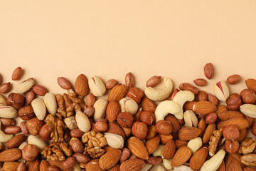 Different nuts on beige background, top view. Vitamin food