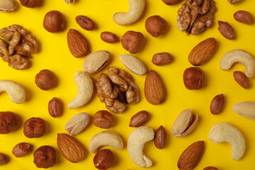 Different nuts on yellow background. Vitamin food