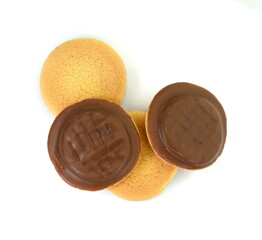 Chocolate coated biscuit cakes with the orange filling isolated over the white background.
