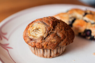 Fototapeta na wymiar homemade rustic banana muffin wit blueberry scone on white plate 