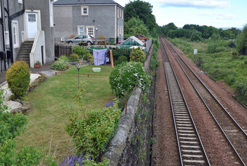 Domestic garden and Railway Tracks Seperated by High Stone Wall 