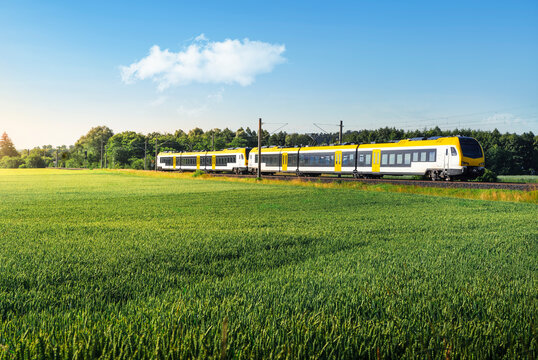 German passenger train in motion. Yellow electric train traveling