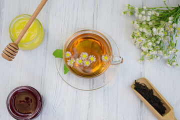 Herbal green tea with camomile on a light background