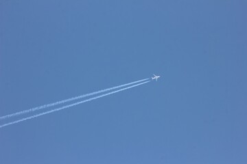 The plane and the track of the plane in the blue sky. The concept of moving forward.