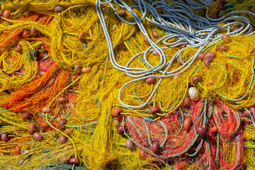 pile of colourful fishing nets with floats and ropes