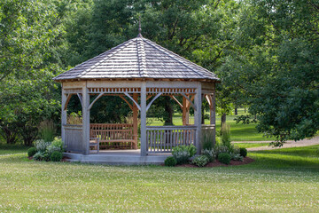 Obraz premium Scenic rural tree lined landscape with wooden gazebo