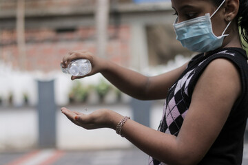 masked girl playing outdoor while keeping social distance during the global pandemic.