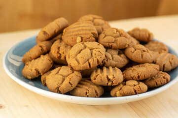 Very tasty peanut butter biscuits on bamboo light brown wooden board, golden baked healthy