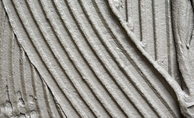 Lined grey concrete as background, top view. Tile installation