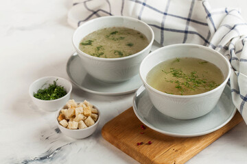 Homemade meaty broth with dill in bowls and crackers. The concept of healthy eating. Copy space.