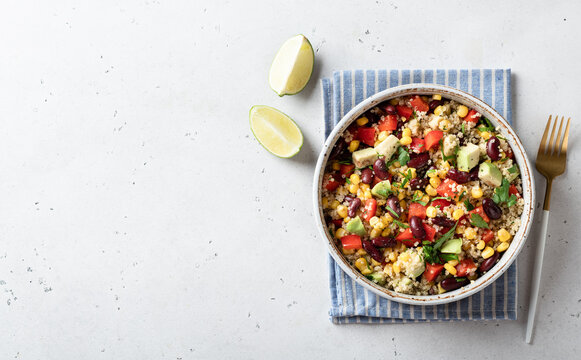 Healthy vegan food concept. Quinoa and fresh vegetable salad on a white background, top view.