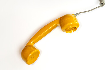 Yellow color handset of a telephone on a white background.