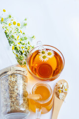 cup of herbal chamomile tea and daisy flowers on white background doctor treatment and prevention of immune concept, medicine - folk, alternative, complementary, traditional medicine
